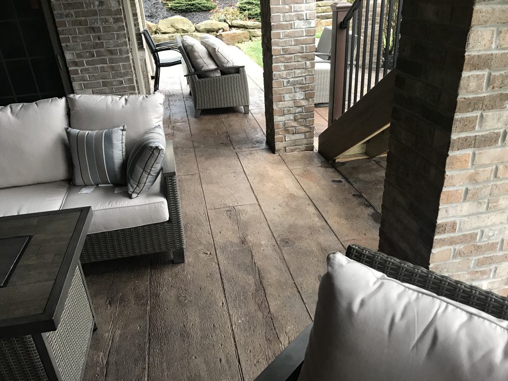 Custom residential floor overlay made with decorative concrete meant to mimic the look of wood.